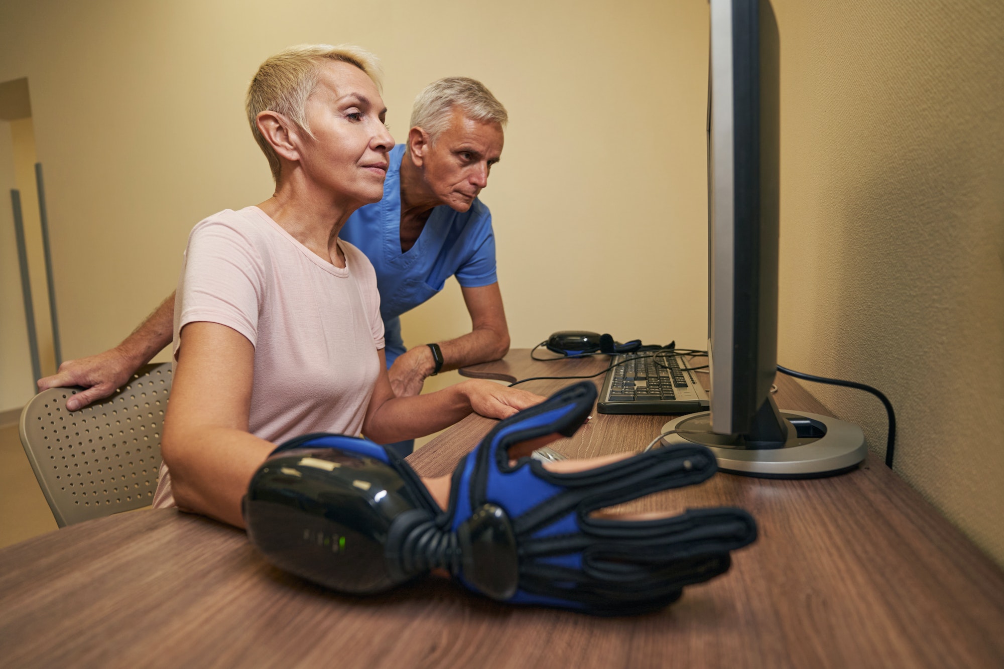 Photo of mature woman during robotic rehabilitation in clinic